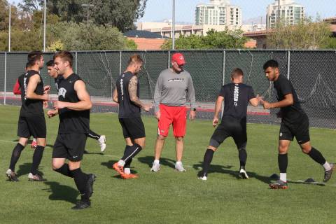 Rich Ryerson, UNLV soccer head coach, center, watches as his players warm up during team practi ...