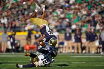 Navy safety Rayuan Lane (18) upends Notre Dame running back Kyren Williams (23) in the first ha ...