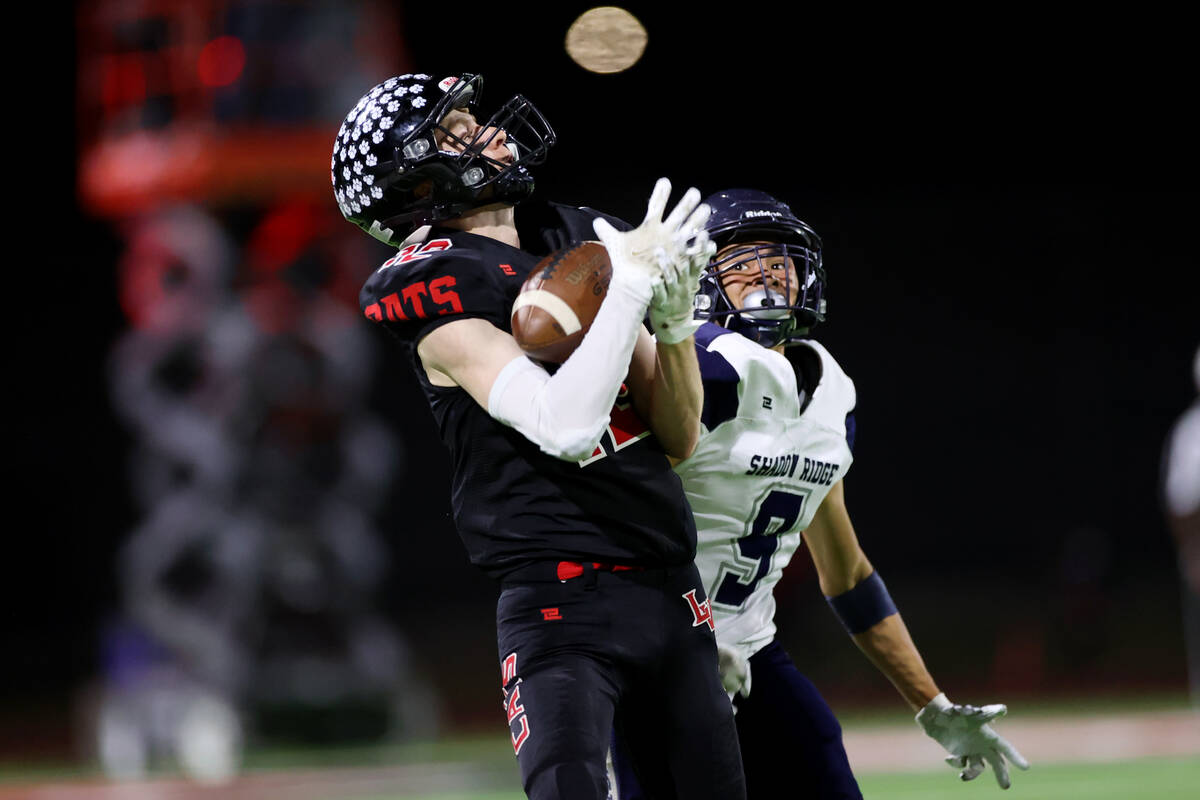 Las Vegas' Andrew Bowen (12) makes.a catch under pressure from Shadow Ridge's Jonah Ruiz (9) in ...