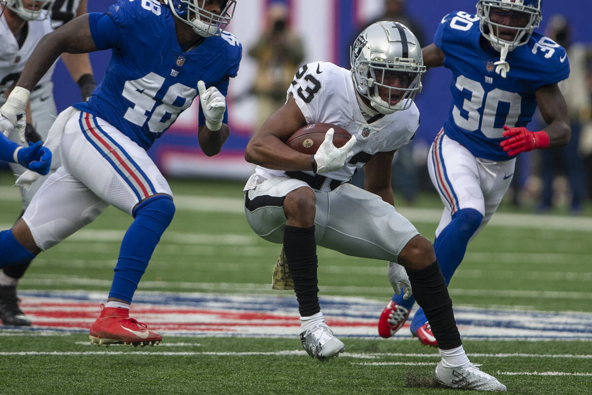 Las Vegas Raiders running back Kenyan Drake (23) looks for running room as New York Giants line ...