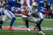 Las Vegas Raiders running back Kenyan Drake (23) looks for running room as New York Giants line ...