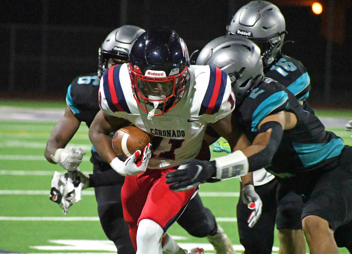 Coronado sophomore Isaiah Bottley (11) runs the ball during a 4A state semifinal game and is ta ...