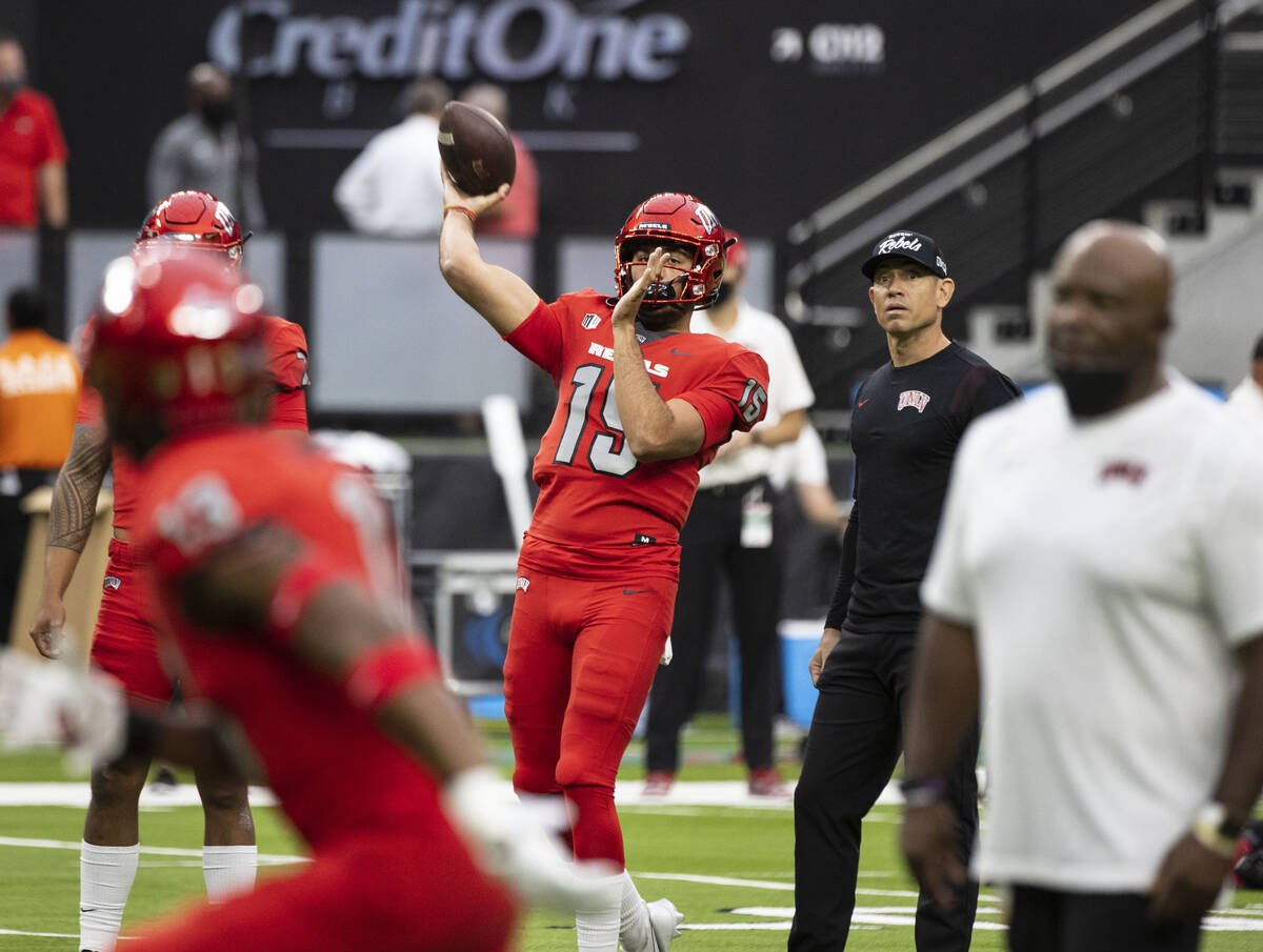 UNLV Rebels quarterback Matthew Geeting (15 throws the ball as head coach Marcus Arroyo looks o ...