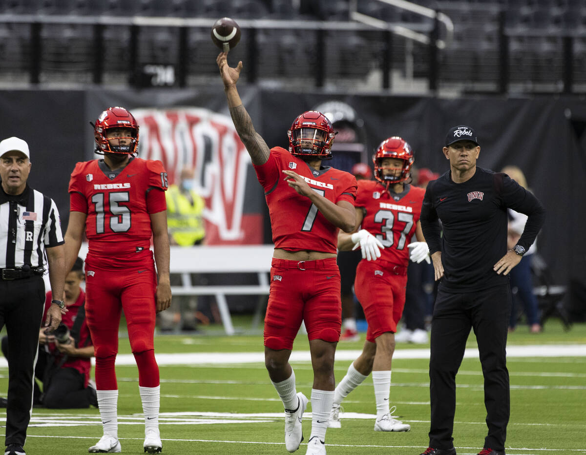 UNLV Rebels quarterback Cameron Friel (7) throws the ball as quarterback Matthew Geeting (15) a ...