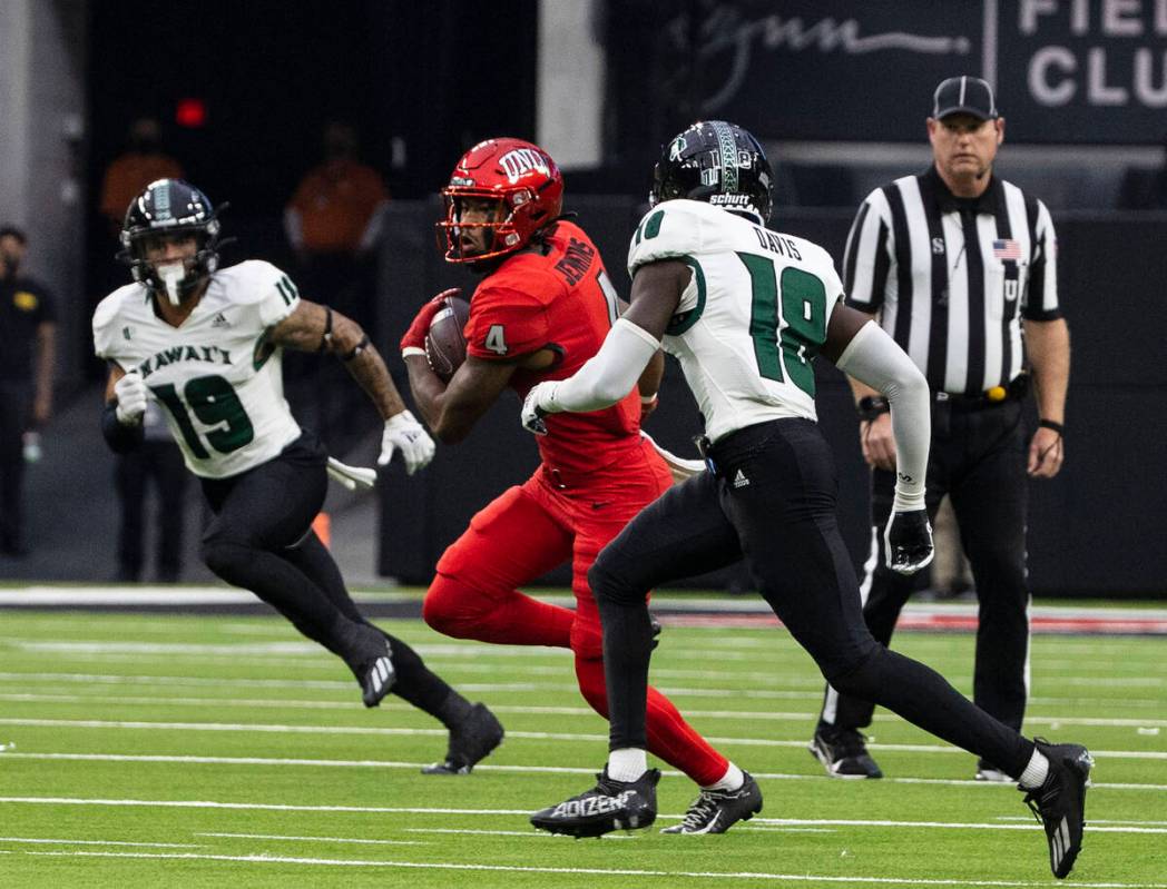 Rebels wide receiver Steve Jenkins (4) chased by Warriors defensive back Quentin Frazier (19) a ...