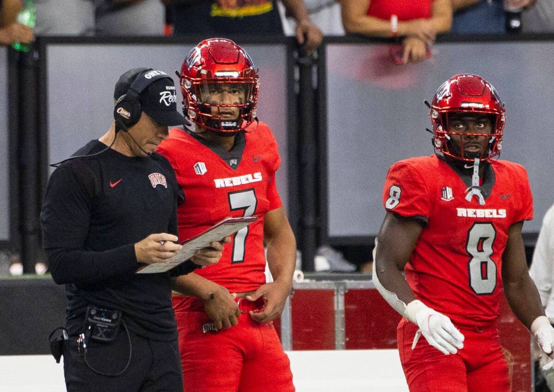 UNLV Rebels head coach Marcus Arroyo checks his game script as quarterback Cameron Friel (7) an ...