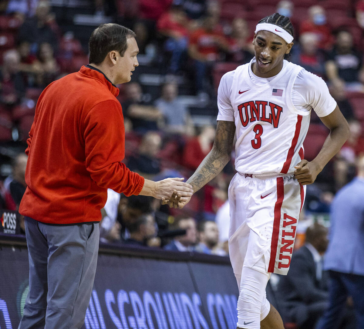 UNLV Rebels head coach Kevin Kruger praises UNLV Rebels forward Donovan Williams (3) as he come ...