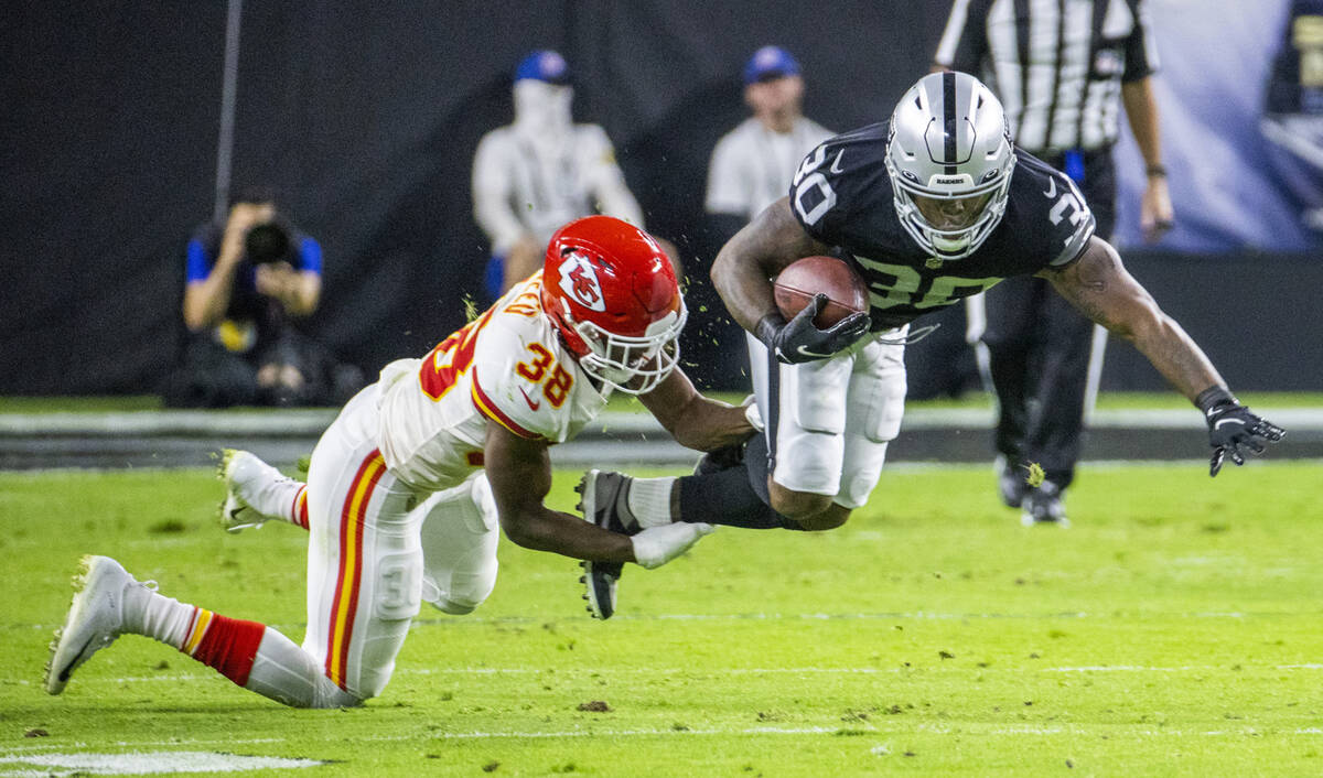 Kansas City Chiefs cornerback L'Jarius Sneed (38) takes out the legs of Raiders running back Ja ...