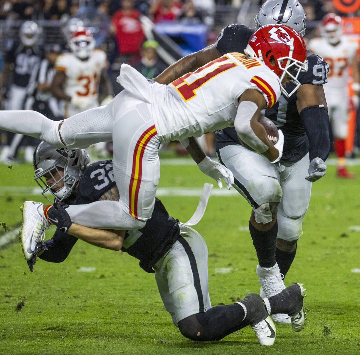 Raiders defensive back Dallin Leavitt (32) tackles Kansas City Chiefs wide receiver Demarcus Ro ...