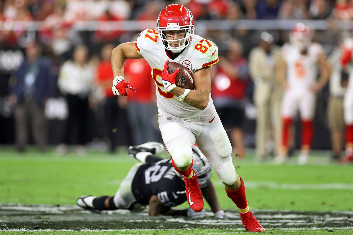 Kansas City Chiefs tight end Travis Kelce (87) runs the ball after dodging a tackle from Raider ...