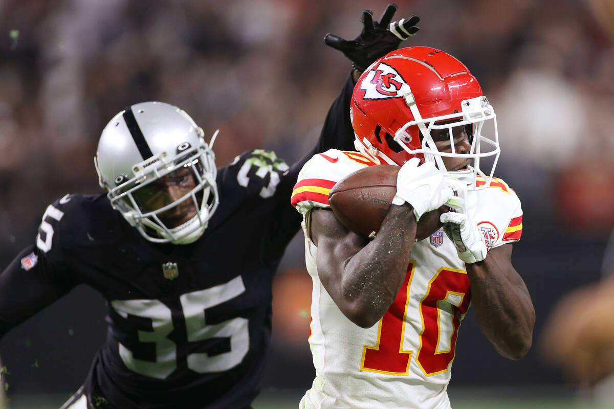 Kansas City Chiefs wide receiver Tyreek Hill (10) makes a catch under pressure from Raiders def ...