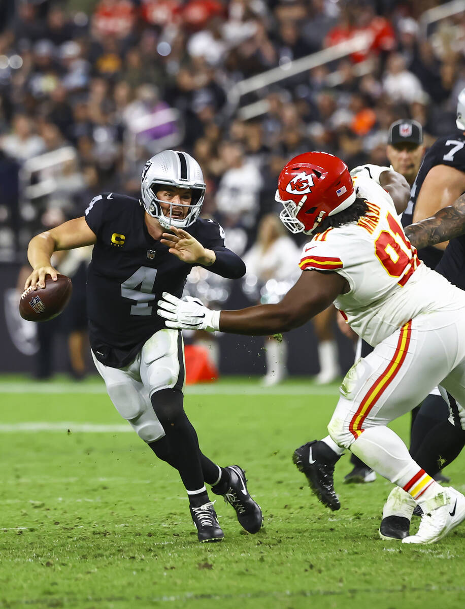 Raiders quarterback Derek Carr (4) tries to avoid getting sacked by Kansas City Chiefs defensiv ...
