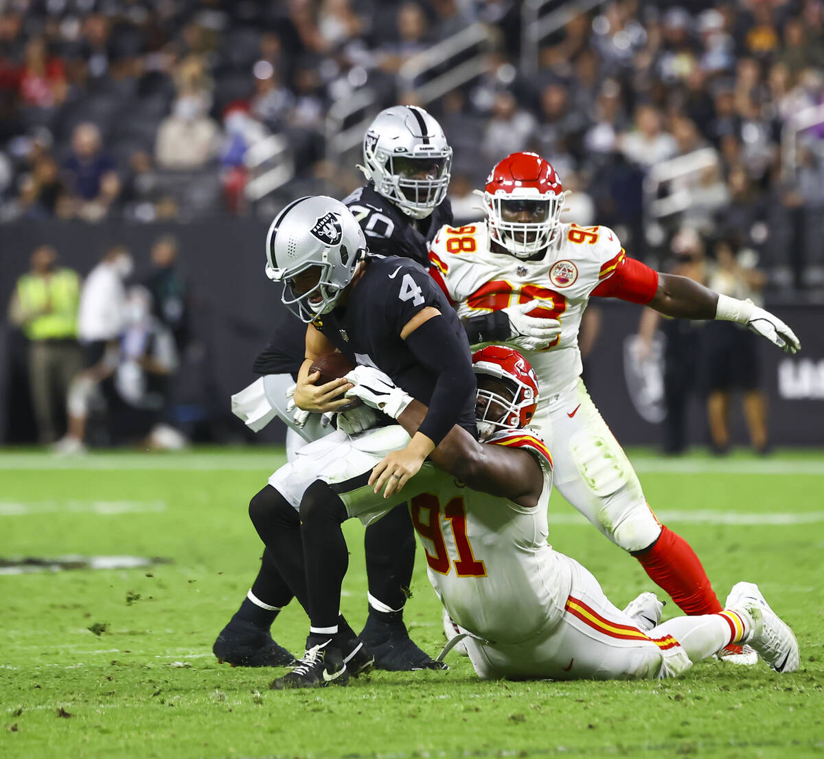 Raiders quarterback Derek Carr (4) gets sacked by Kansas City Chiefs defensive tackle Derrick N ...