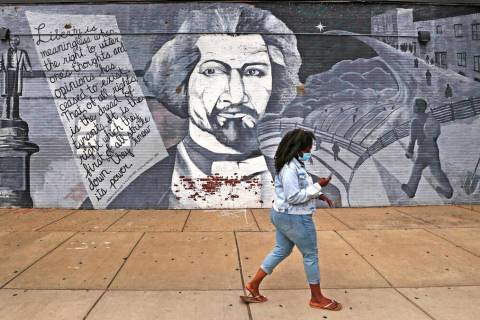 In this Wednesday, June 24, 2020, photograph, a pistillate   walks past   a mural successful  tribute to Frederic ...