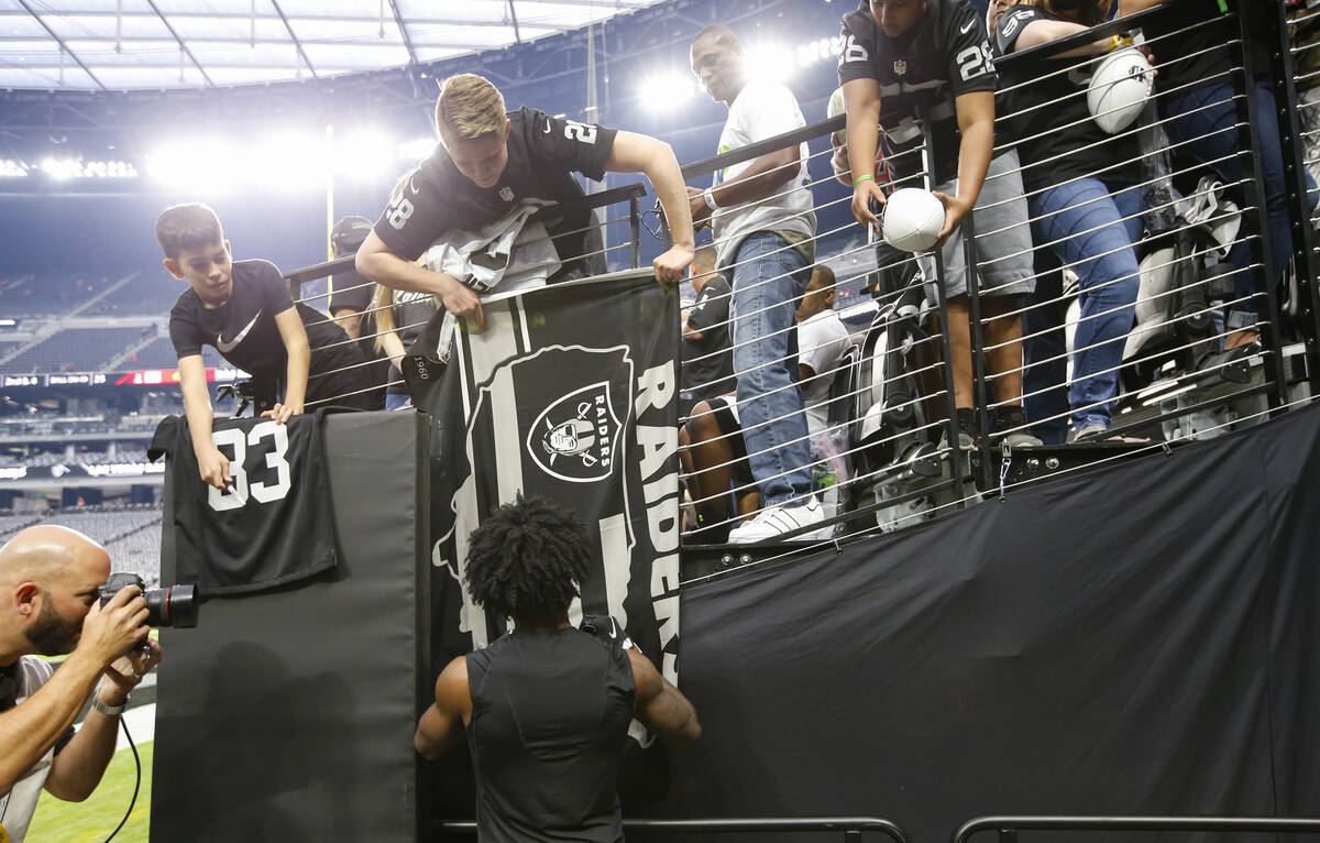 Las Vegas Raiders cornerback Nate Hobbs autographs items for fans earlier  the commencement  of an NFL ga ...