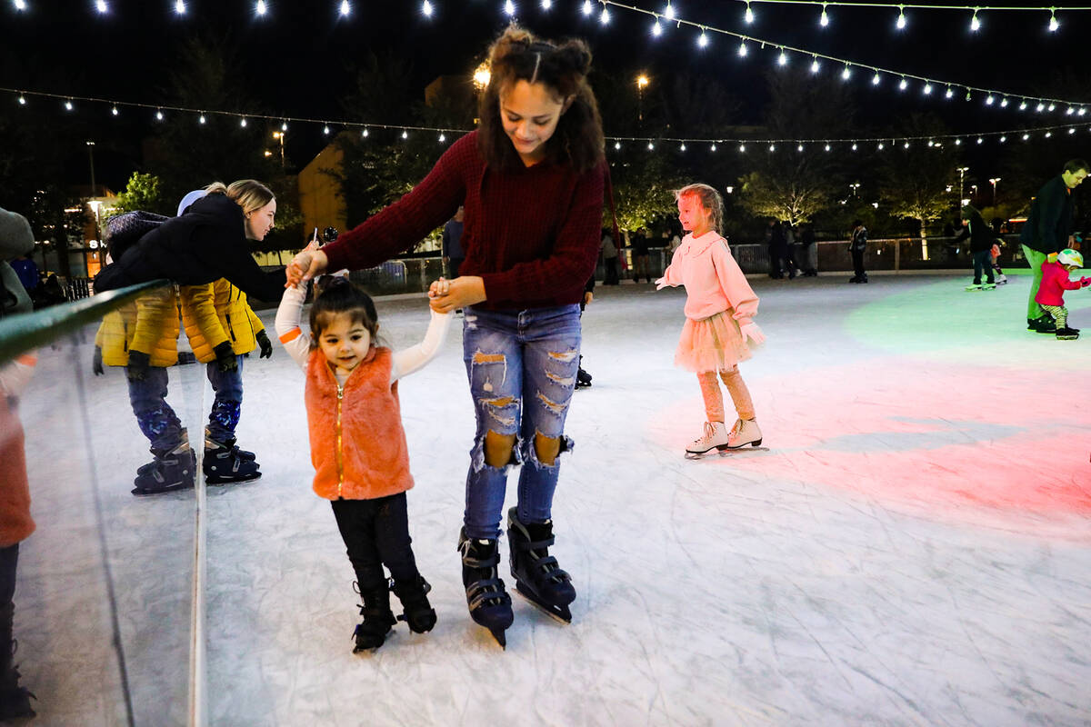 Mia Meija, 11, guides her little sister Gabby Barreto, 2, on the ice at the Rock Rink in Downto ...