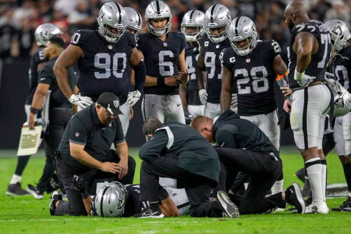 Raiders fullback Alec Ingold (45) is looked at by trainers as his teammates look on after being ...