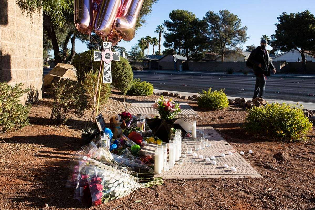 A pedestrian walks past a makeshift memorial to honor Tina Tintor, 23, at South Rainbow Bouleva ...