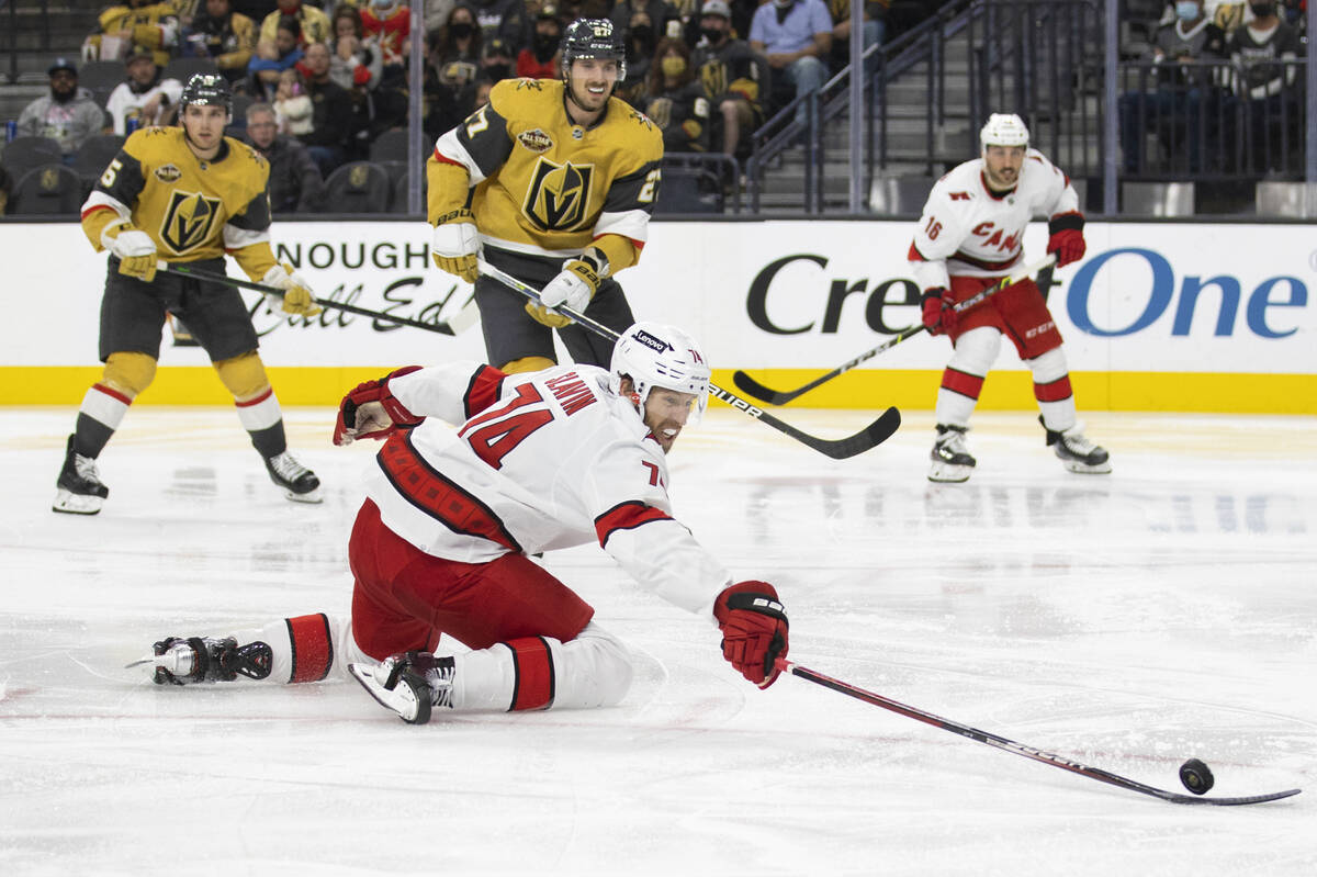 Carolina Hurricanes defenseman Jaccob Slavin (74) fights for a loose puck with Golden Knights d ...