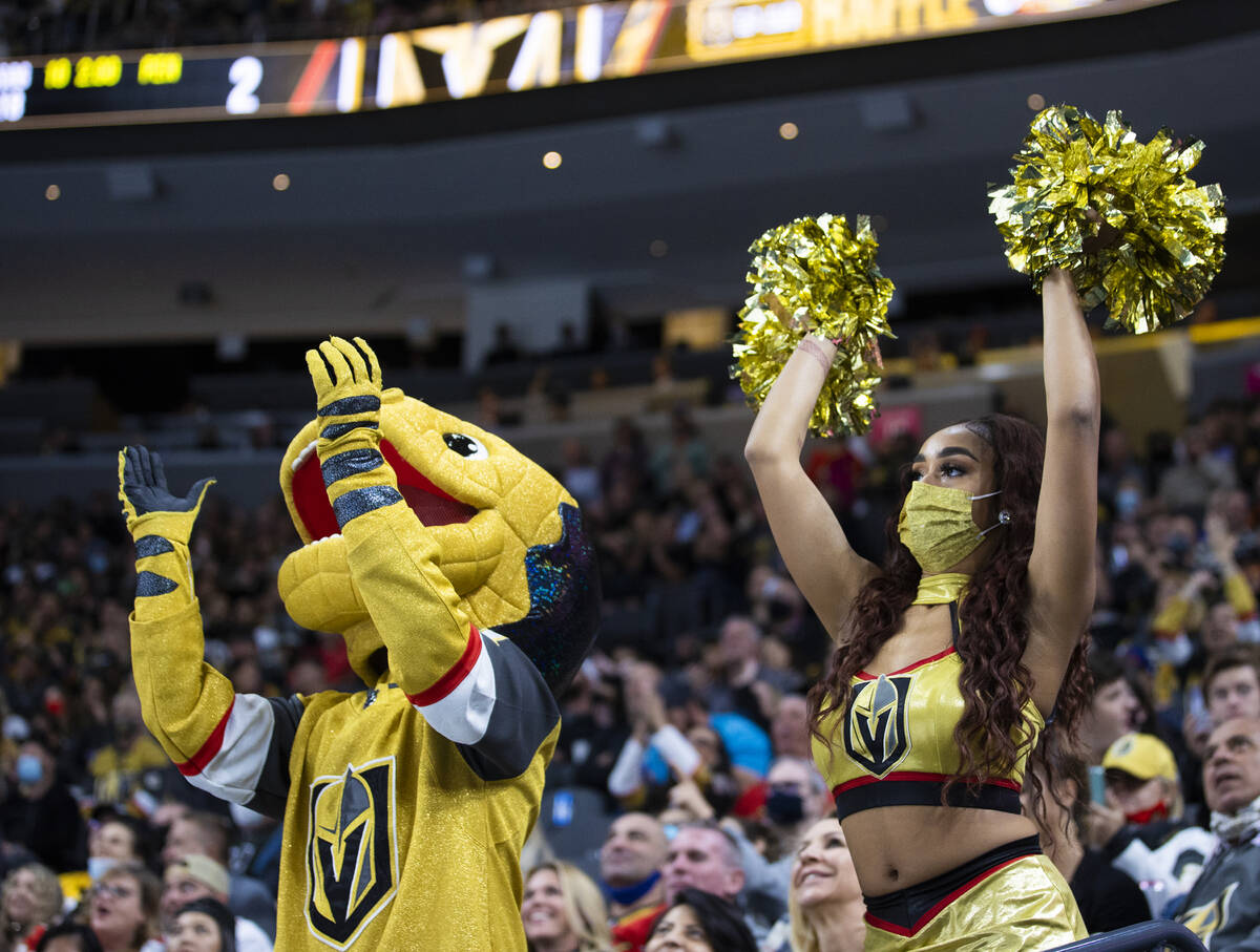 The Golden Knights mascot Chance, left, cheers for Vegas in the third period during an NHL hock ...