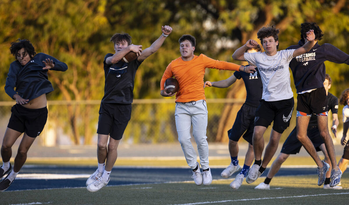 The Meadows High School football players, including Ben Vinocur, center, warm up during practic ...