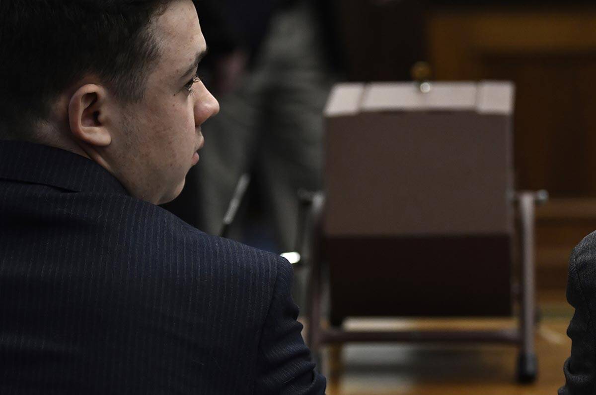 Kyle Rittenhouse sits next to the tumbler that he will use to select the jurors who will not pa ...