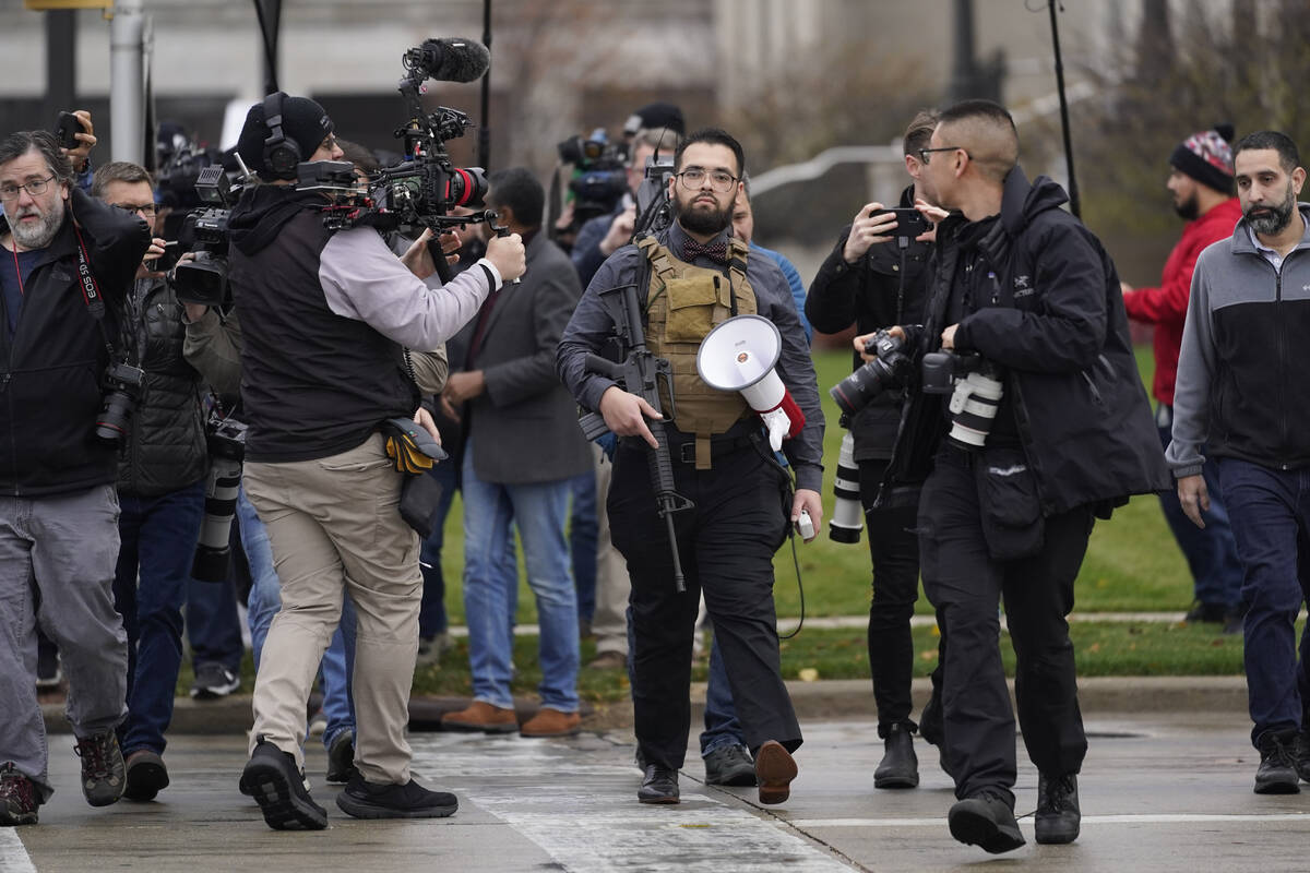 A protester carrying a rifle leaves the the Kenosha County Courthouse after speaking with Kenos ...