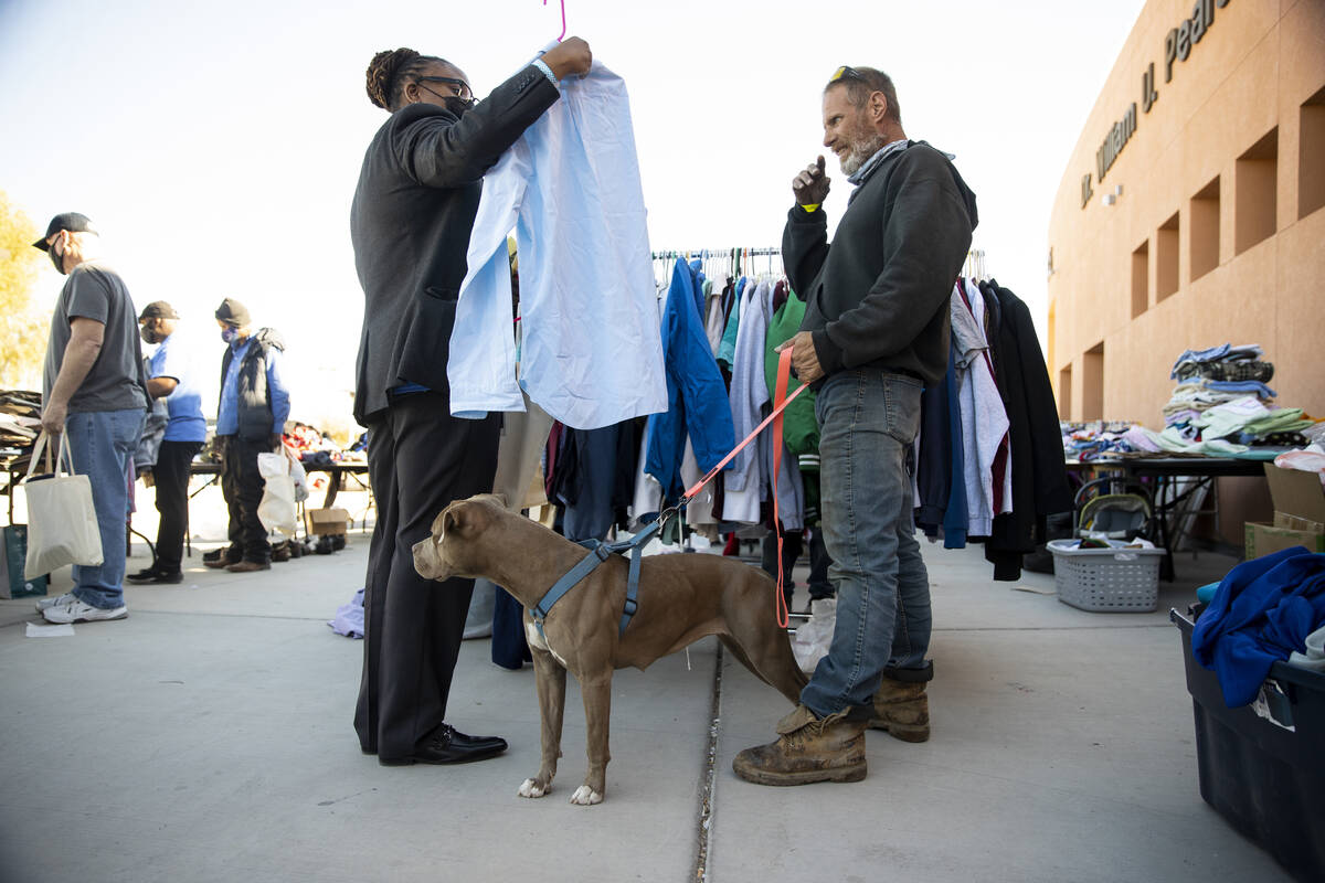 Michael Christ, right, with his dog Ice, receives assistance with shopping for free clothes fro ...