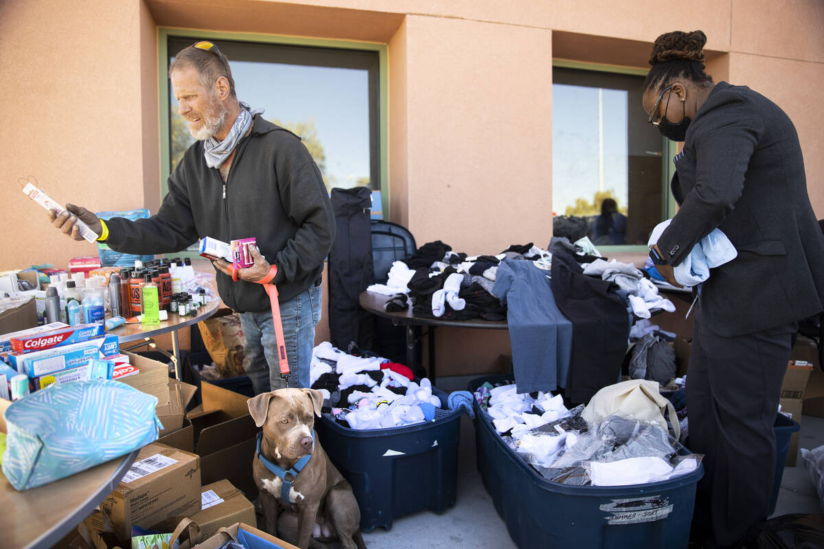 Michael Christ with his dog Ice shops for free clothes as volunteer Angel Lash works during the ...