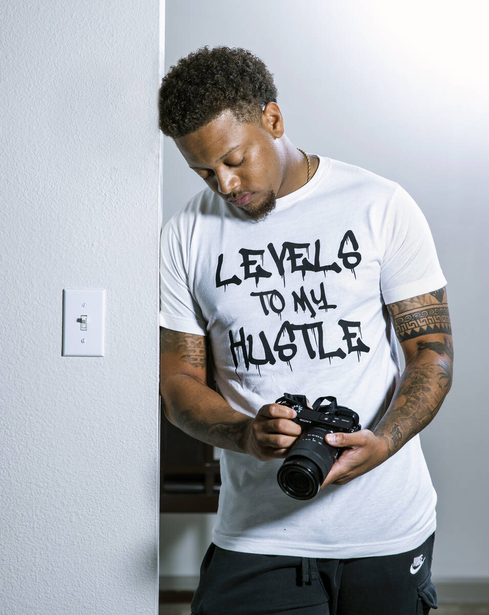 Malachi Miles wears a T-shirt and holds a camera that belonged to his friend Curtis Abraham, wh ...