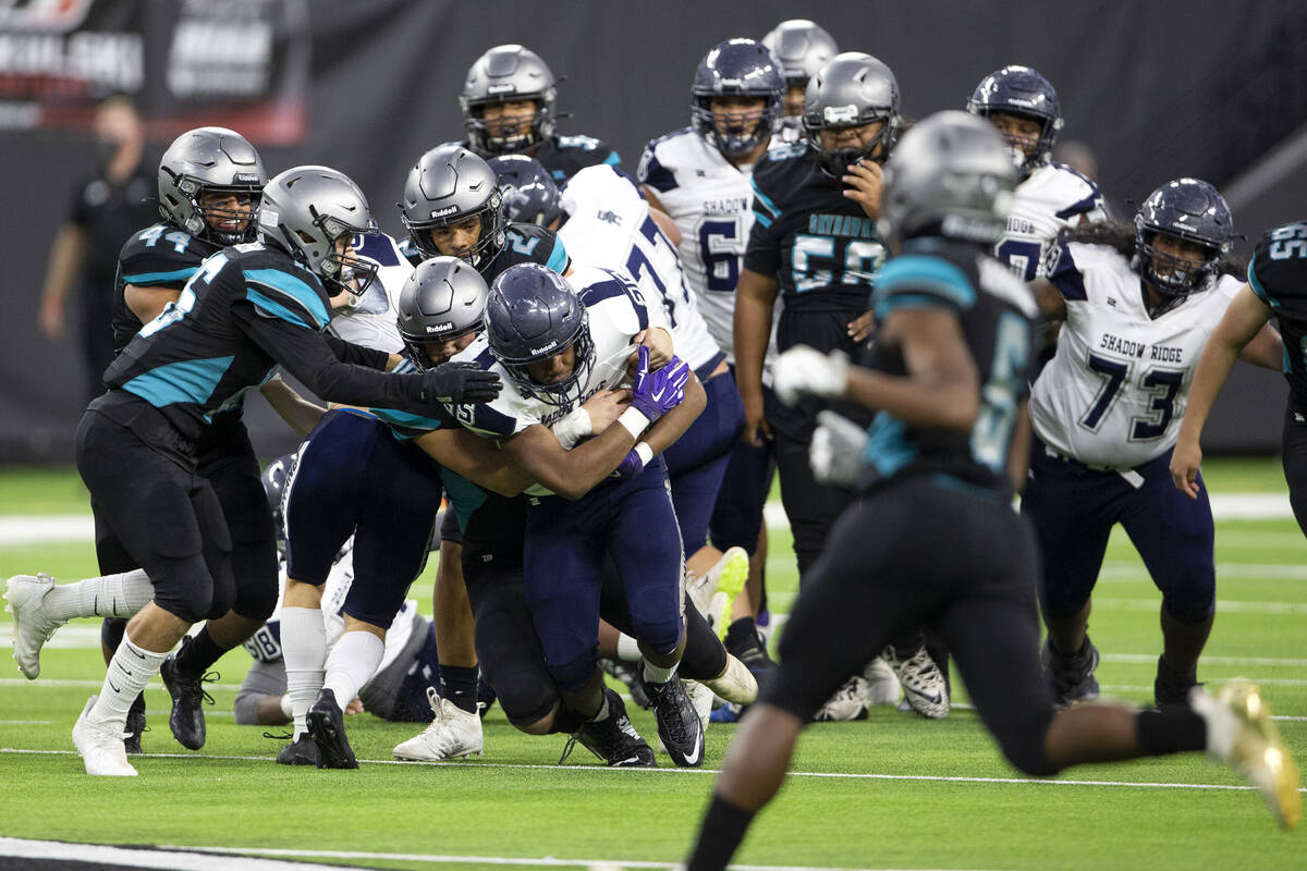Shadow Ridge running back Jaquieze Holland (25) rushes the ball as Silverado defenders tackle h ...