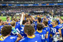 Moapa Valley holds up their Class 3A football state championship trophy after winning the game ...