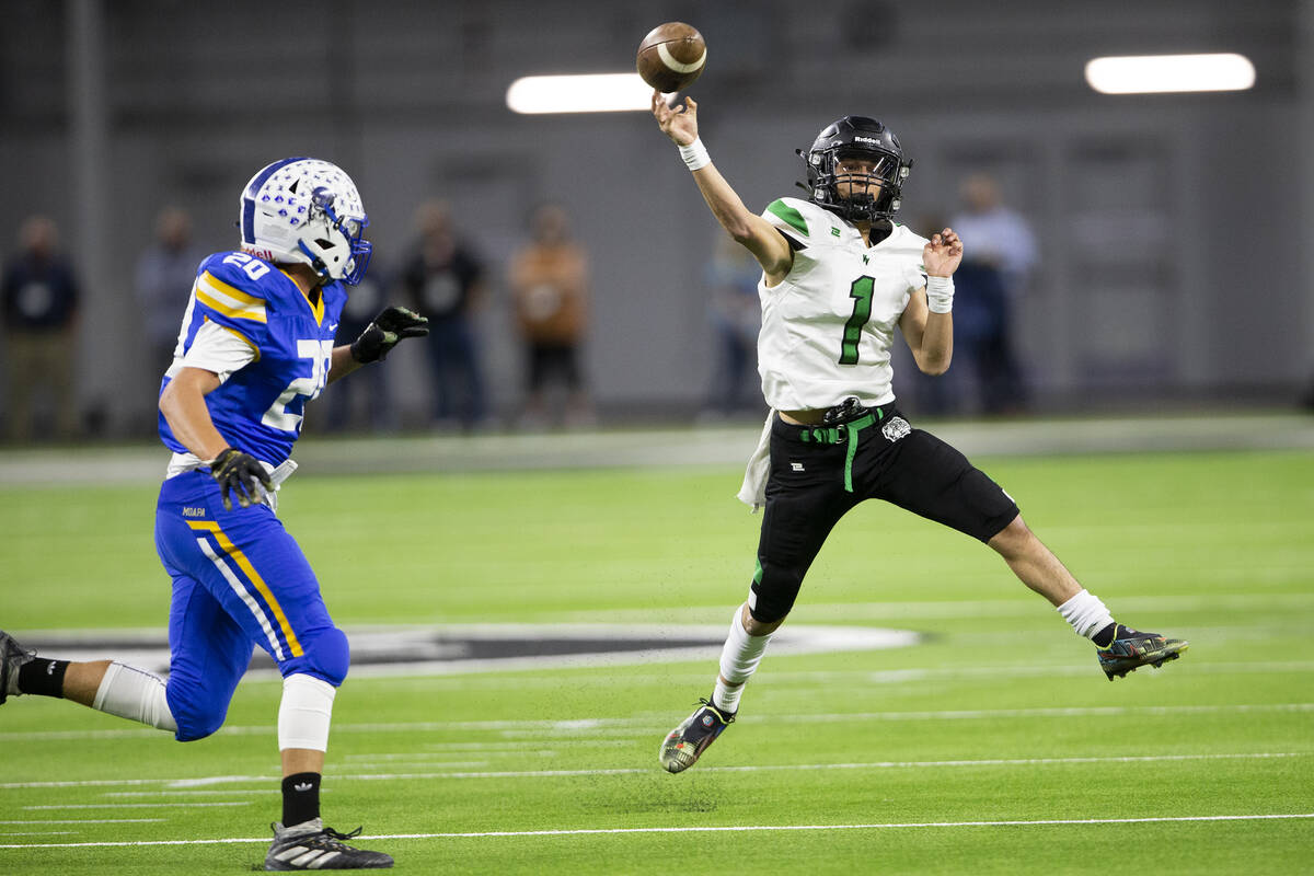 Virgin Valley quarterback Gavin Brown (1) passes as Moapa Valley defensive lineman Elias Cox (2 ...