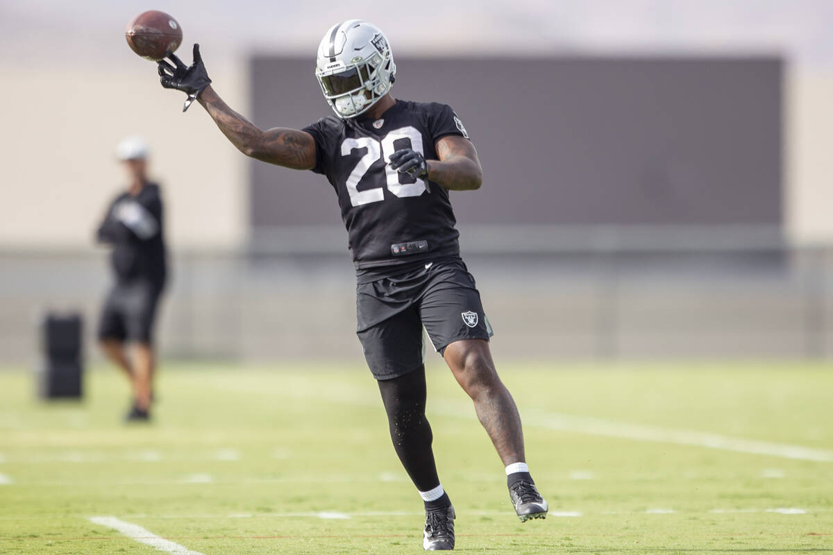 Raiders running back Josh Jacobs (28) throws the football during a practice session at Raiders ...