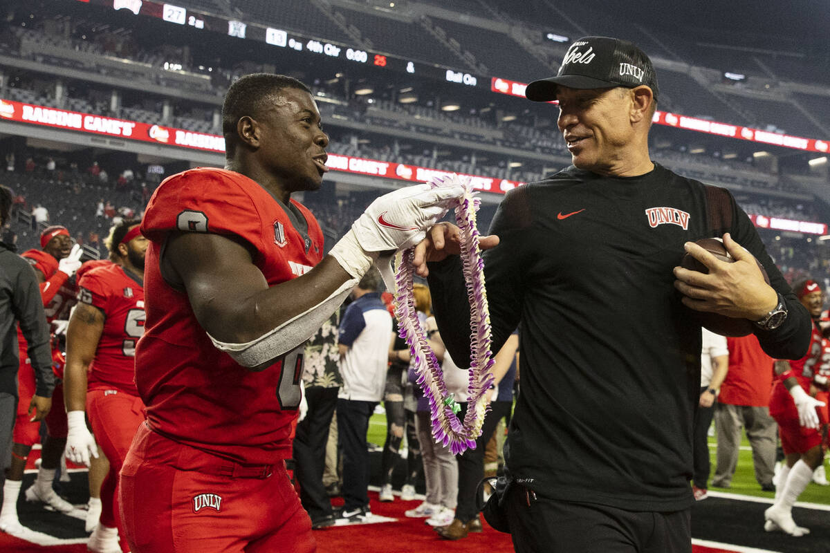 UNLV Rebels running back Charles Williams (8) presents Hawaiian Leis to head coach Marcus Arroy ...