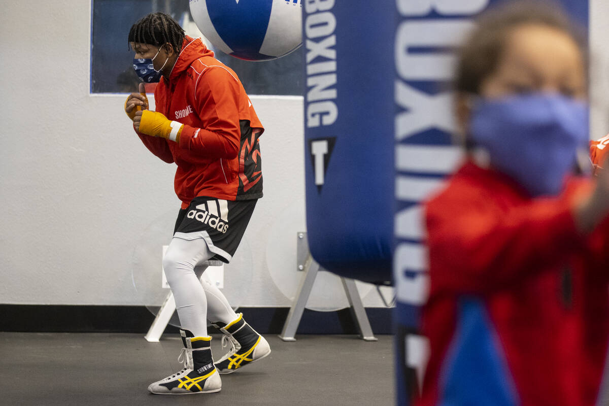 Shawn Porter, left, with his son Shaddai, 3, in the foreground, works out in preparation for an ...
