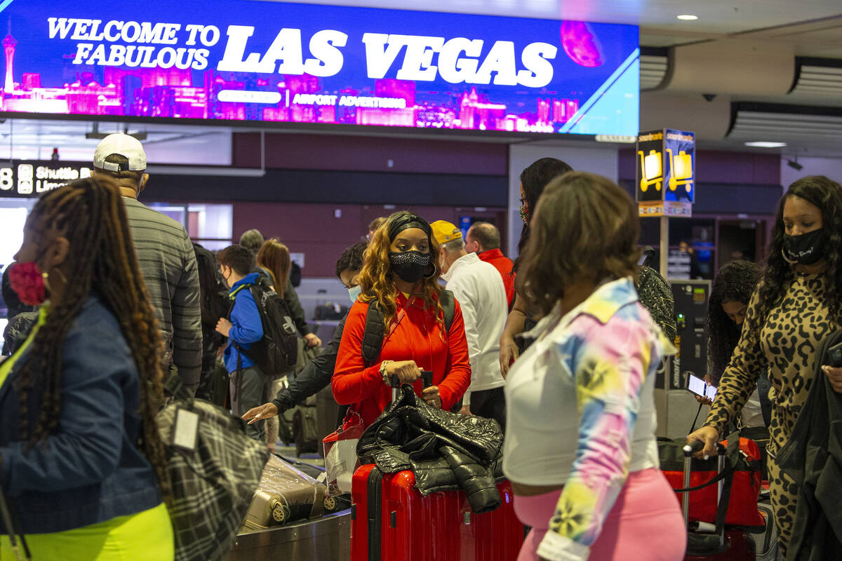 Visitors to Las Vegas, wearing personal protective equipment to prevent the spread of COVID-19, ...