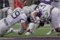 Kansas State running back Deuce Vaughn, center, gets past West Virginia safety Scottie Young (1 ...