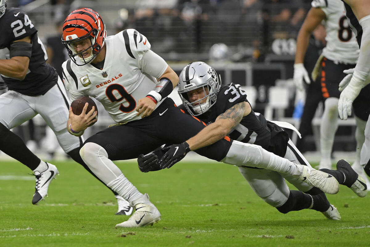 Las Vegas Raiders defensive back Dallin Leavitt (32) tackles Cincinnati Bengals quarterback Joe ...