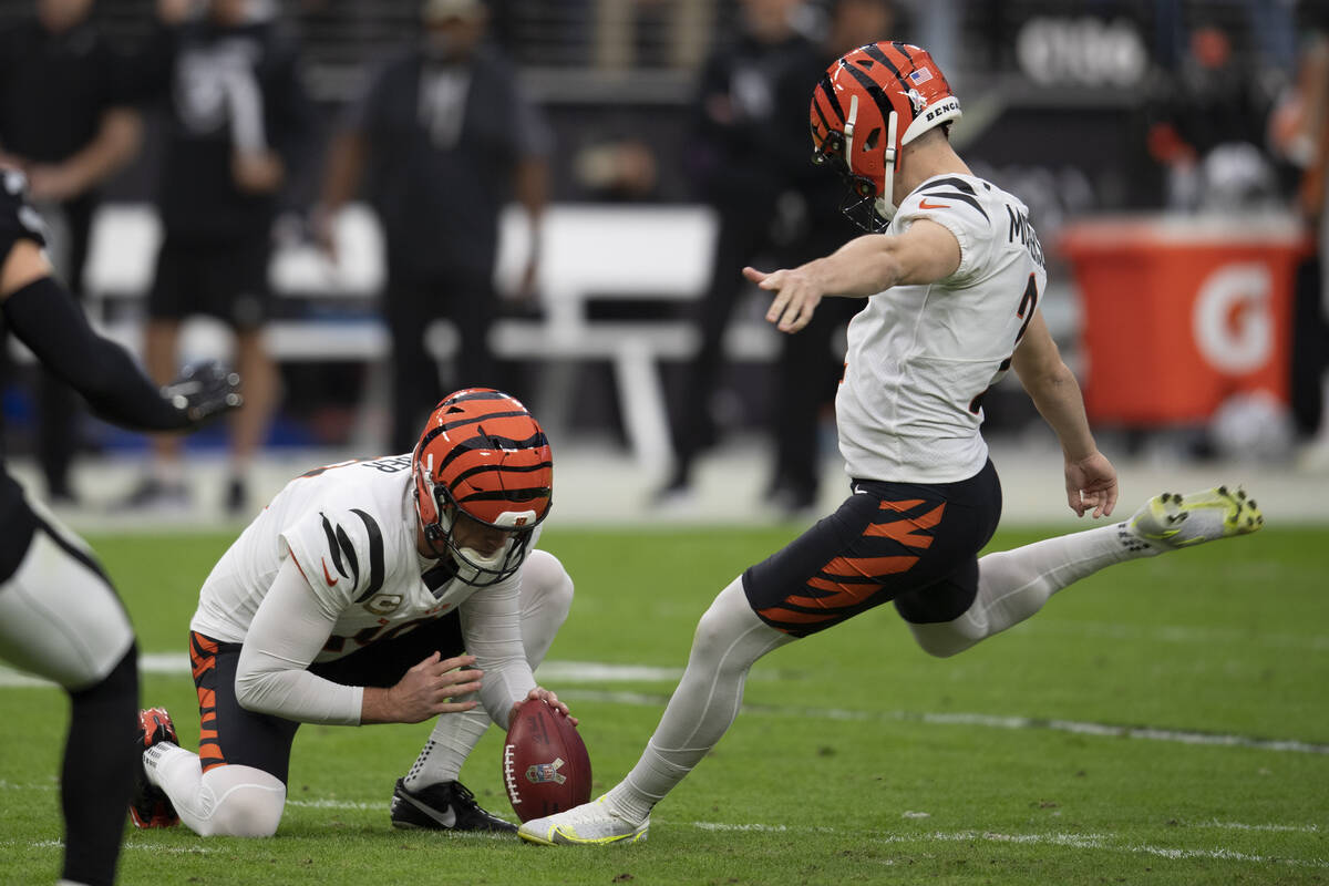 Cincinnati Bengals punter Kevin Huber (10) holds for kicker Evan McPherson (2) as he kicks feed ...