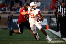 Iowa State's Breece Hall (28) tries to break away from Texas Tech's Colin Schooler (17) during ...