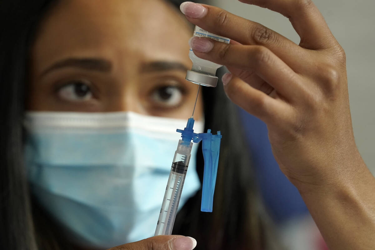 Licensed practical nurse Yokasta Castro, of Warwick, R.I., draws a Moderna COVID-19 vaccine int ...