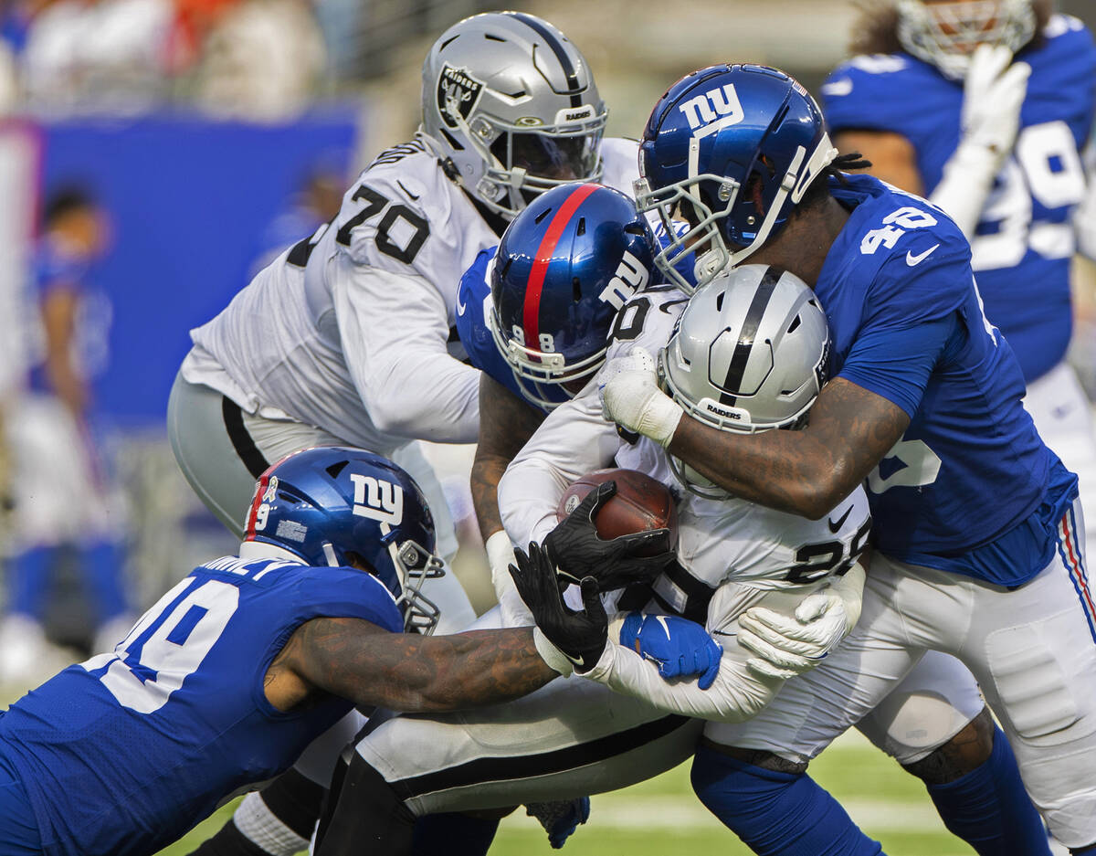 Las Vegas Raiders running back Josh Jacobs (28) is wrapped up by New York Giants linebacker Tae ...