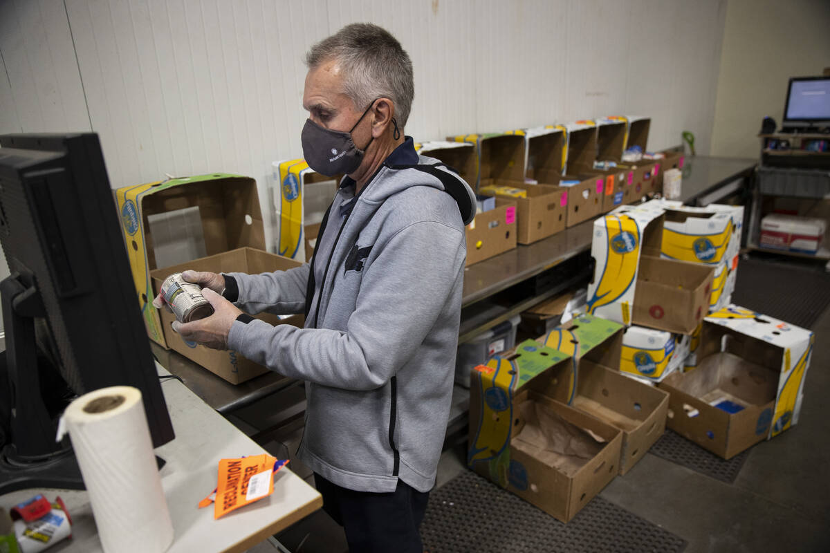 Volunteer Mark Hawley assorts through donated food inside of the Three Square North Campus ware ...
