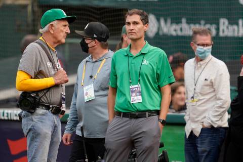 Oakland Athletics President Dave Kaval, center, talks with photographer Michael Zagaris, left, ...