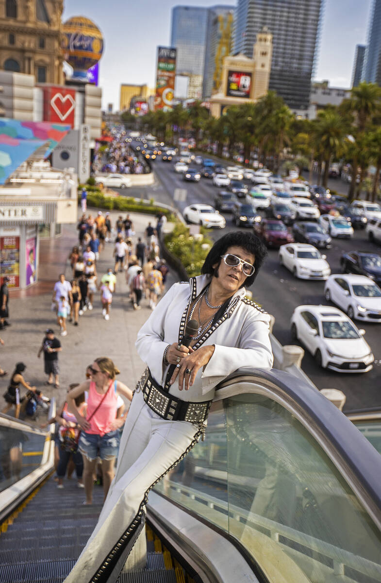 Chris Johnson, known as "Counterfeit Elvis," makes his way up the escalator on The Strip during ...