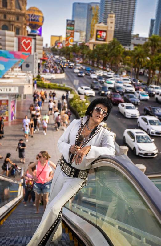 Chris Johnson, known as "Counterfeit Elvis," makes his way up the escalator on The Strip during ...