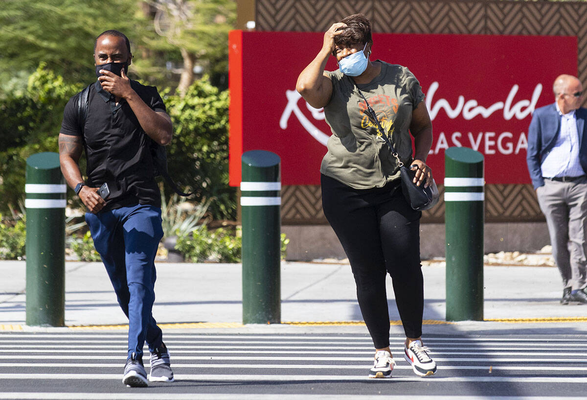 Pedestrians try to keep their balance as they walk against strong winds at the corner of Las Ve ...