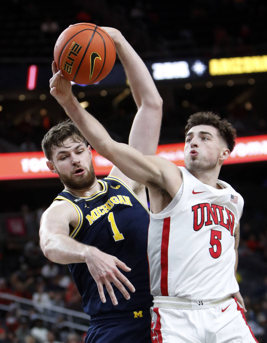 UNLV Rebels guard Jordan McCabe (5) and Michigan Wolverines center Hunter Dickinson (1) compete ...