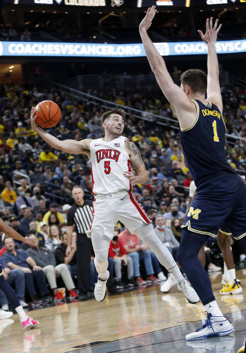 UNLV Rebels guard Jordan McCabe (5) passes the ball as Michigan Wolverines center Hunter Dickin ...